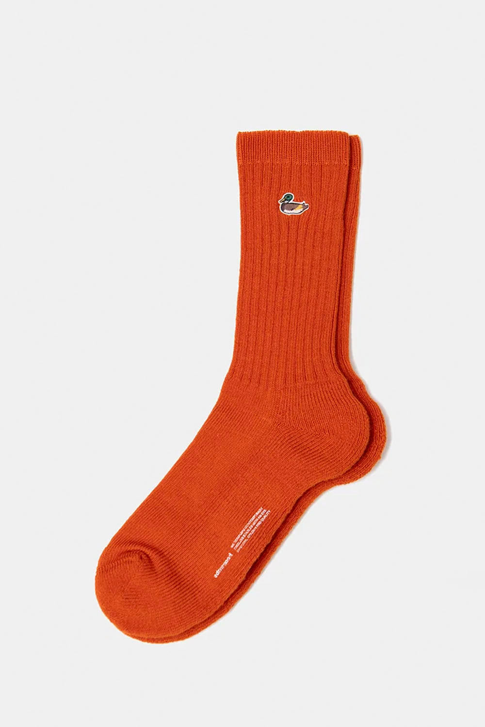 A single bright orange ribbed crew sock with a small embroidered crocodile logo on the cuff, displayed on a light gray background.