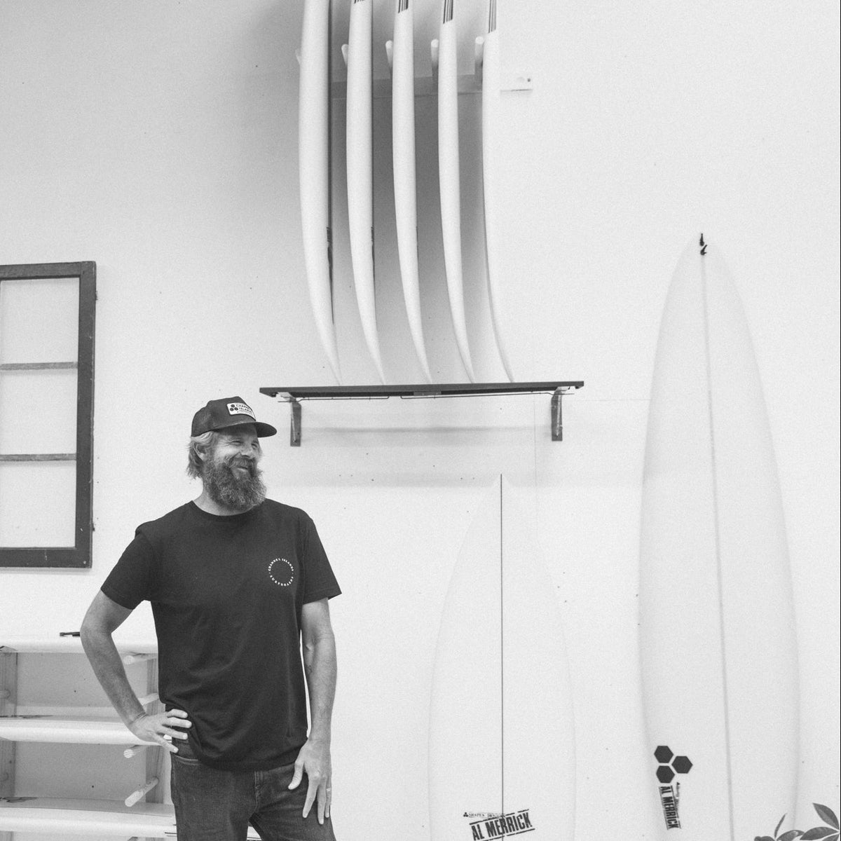 Britt Merrick standing in a room with surfboards on the wall