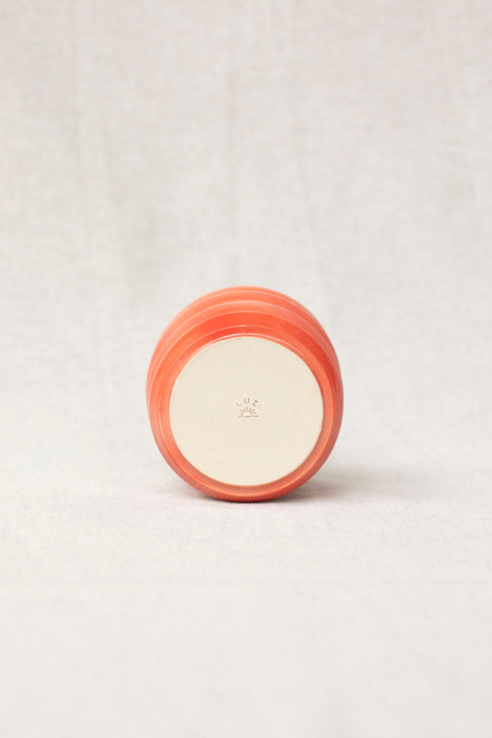 Small round container with a peach-colored lid on a light gray background