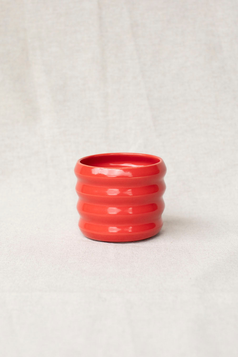 Red textured vase on a light gray background