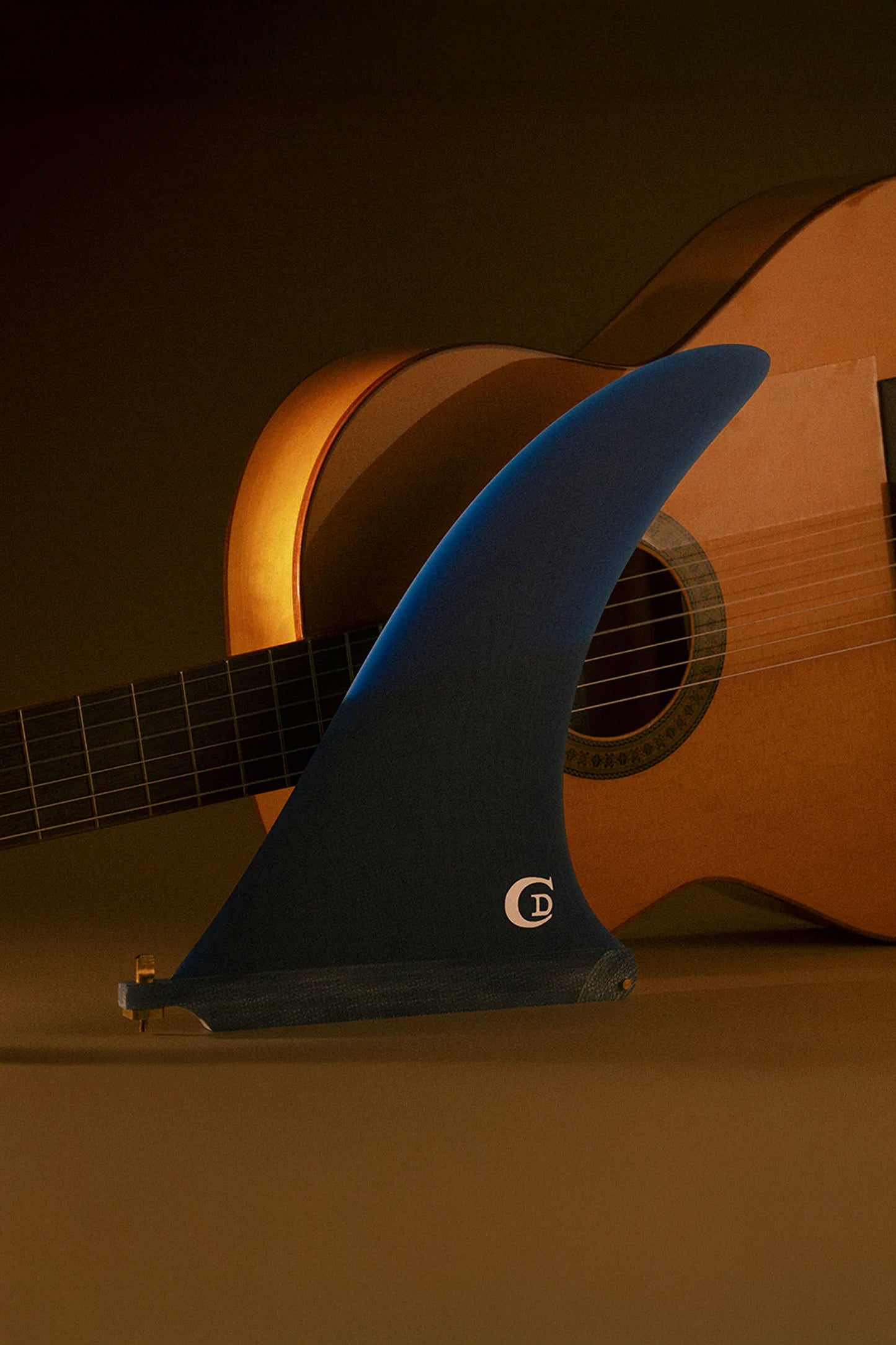 Blue surf fin with a logo on a guitar background