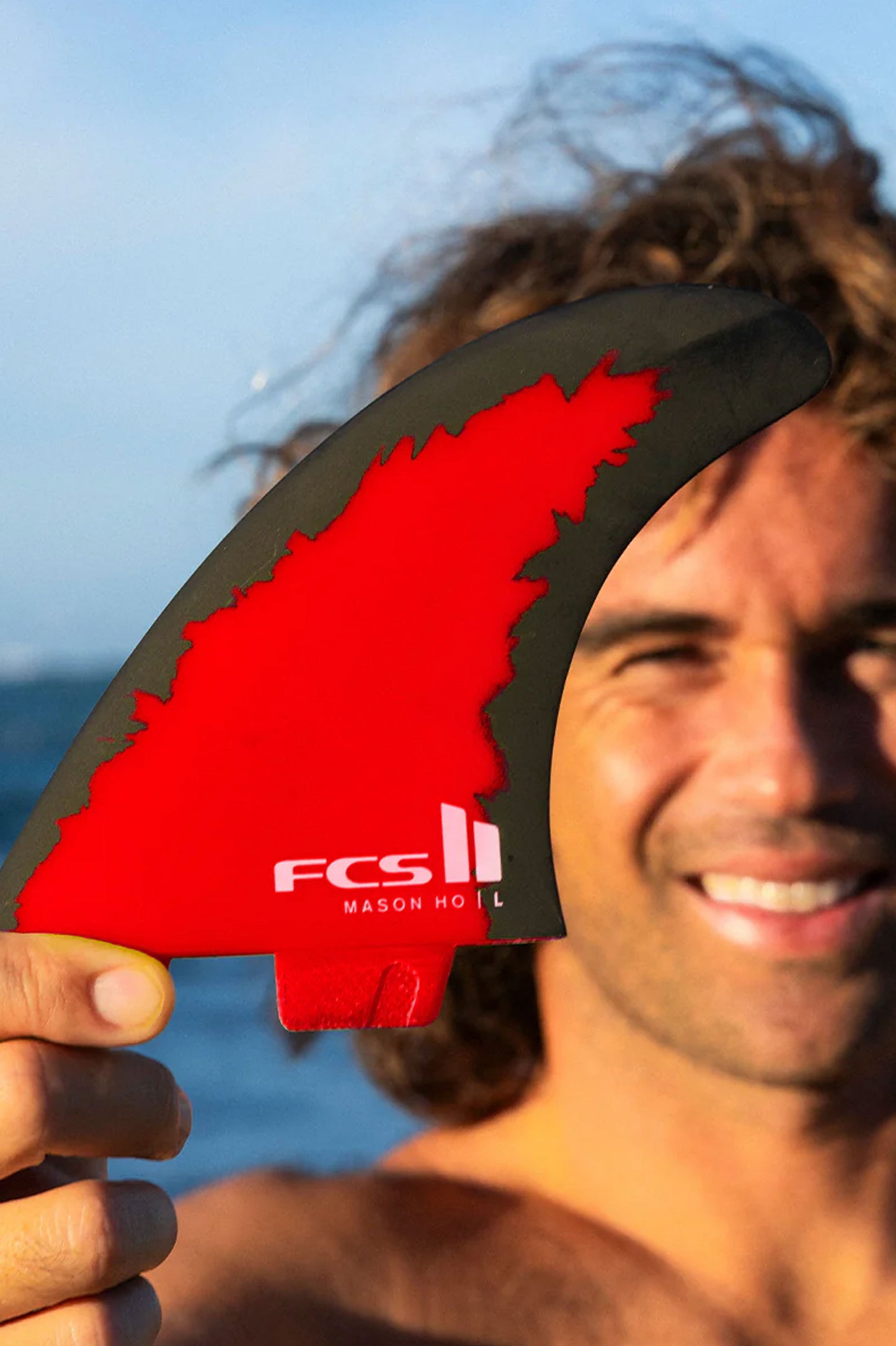 FCS II Mason Ho Code Red surf fin showing its red and black graphic.