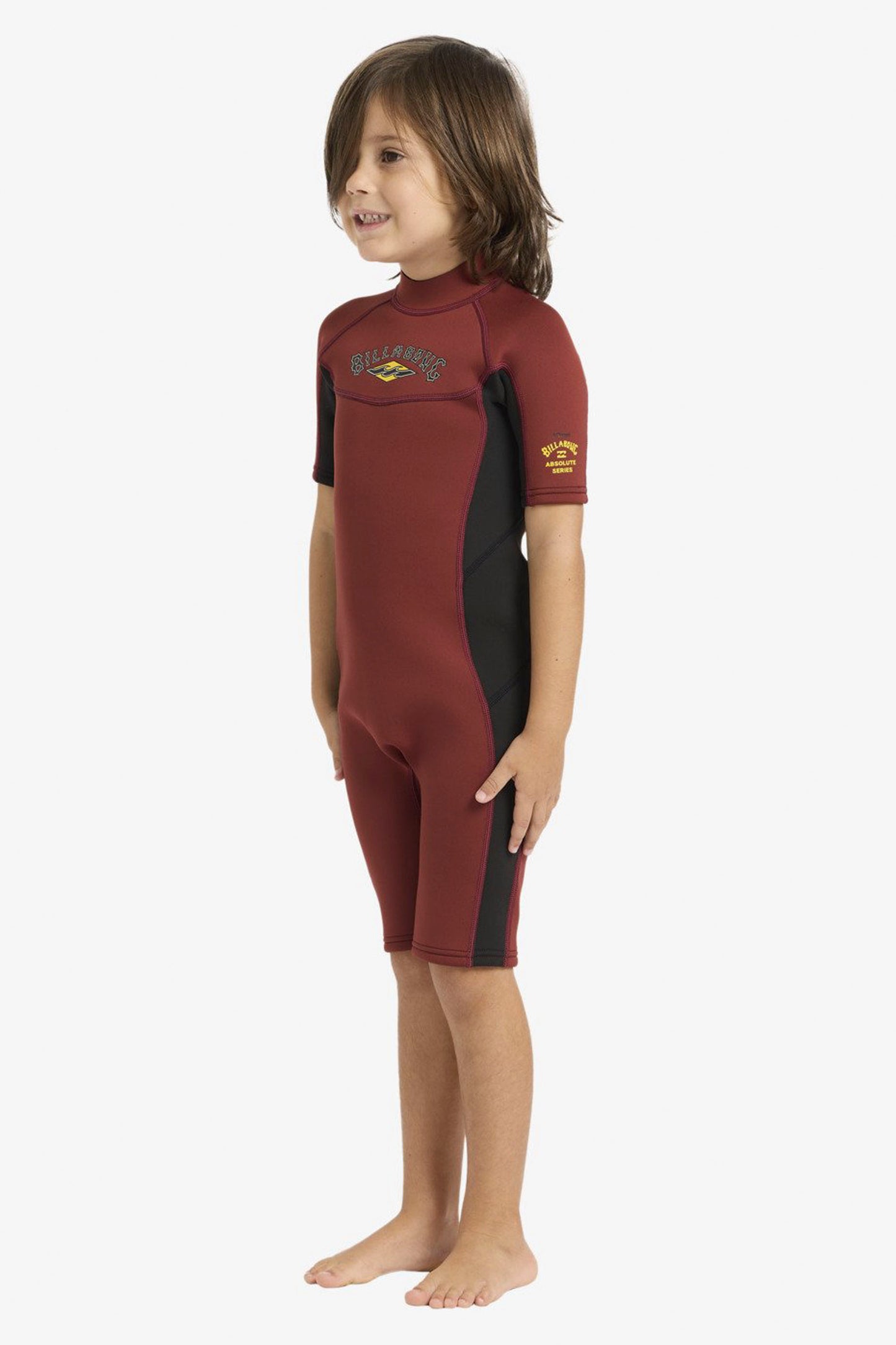 Child wearing a  red Billabong Absolute 2/2mm wetsuit on a white background