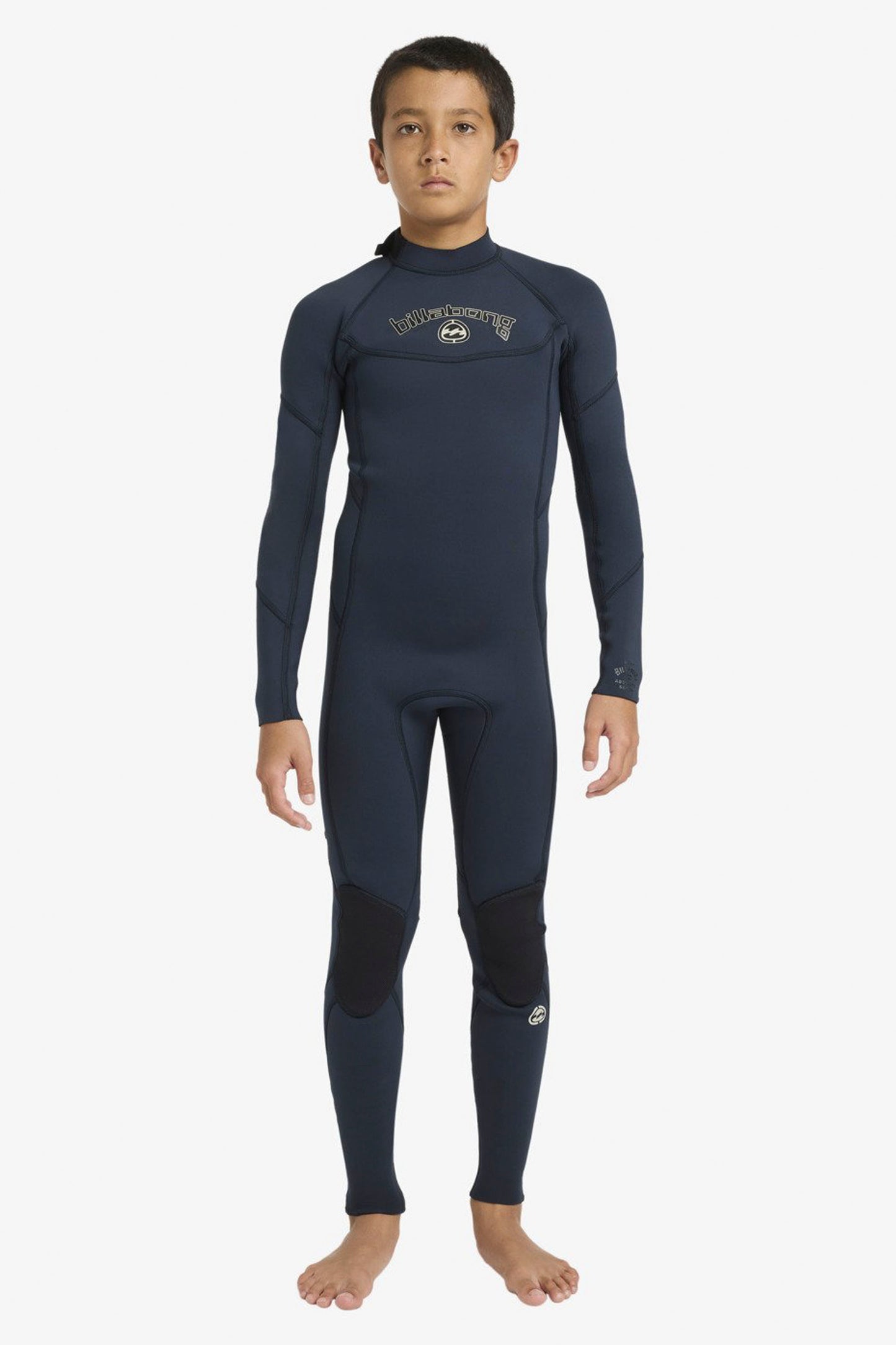 Boy wearing a Billabong Absolute 3/2mm navy wetsuit on a white background