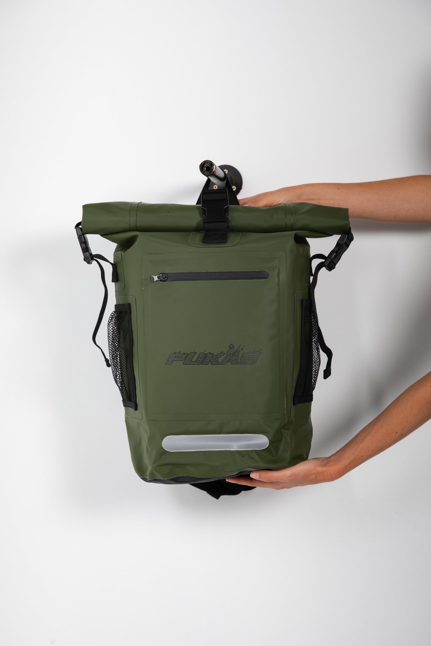 Green backpack with a brand logo held by a person on a white background