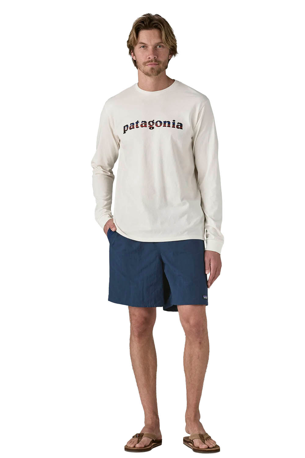 A person wearing navy blue Patagonia shorts and a light cream long-sleeve shirt against a plain white background.