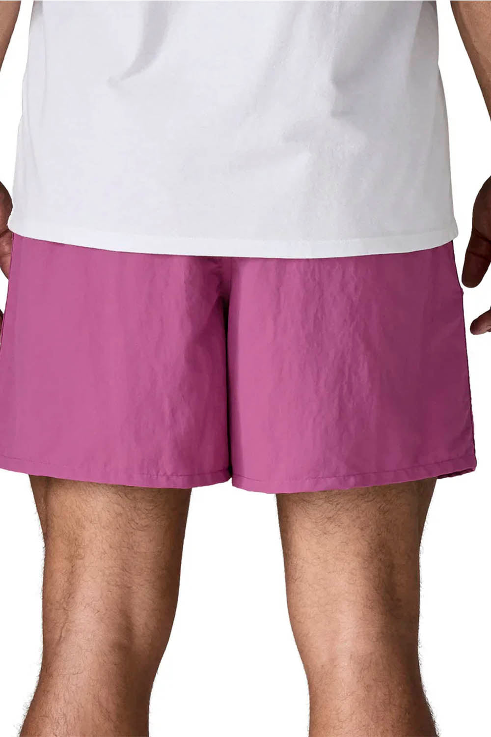 A close-up of a person wearing purple athletic shorts and a white t-shirt against a plain white background.
