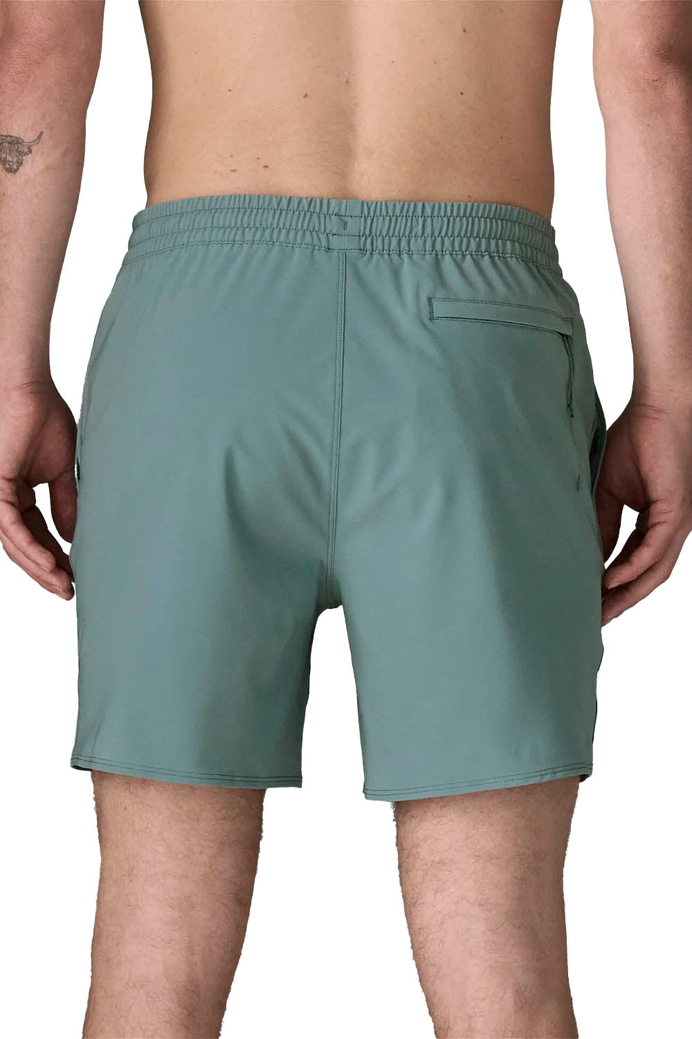 Rear view of a person wearing sage green athletic shorts against a plain white background.