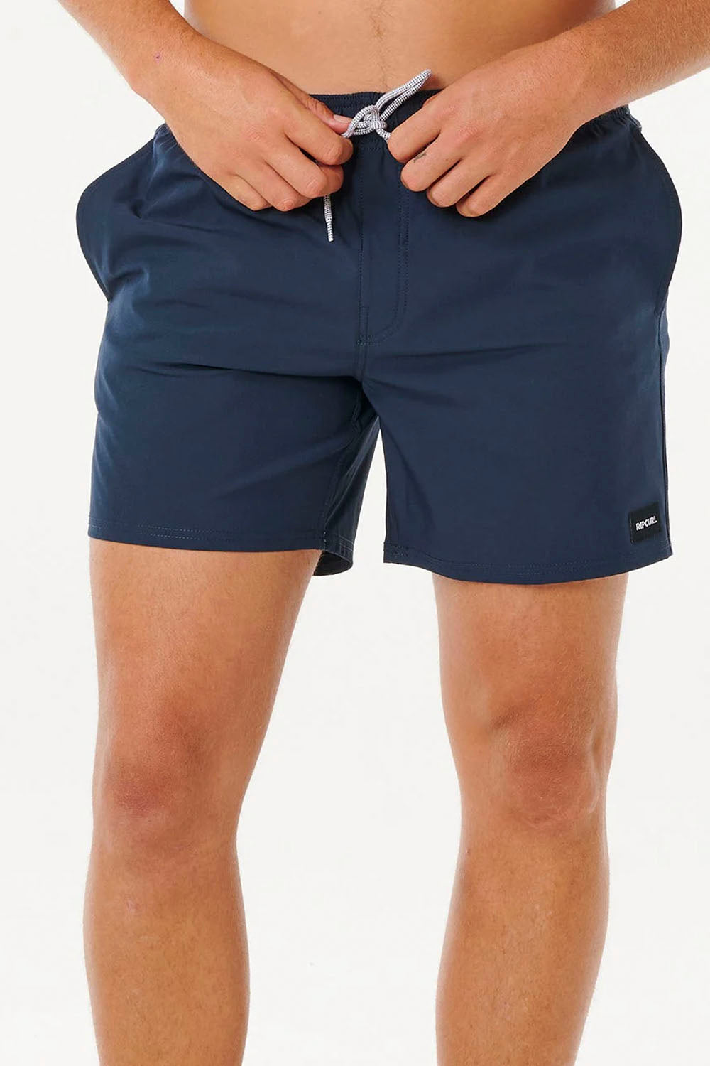 Navy blue swim shorts worn by a person on a white background