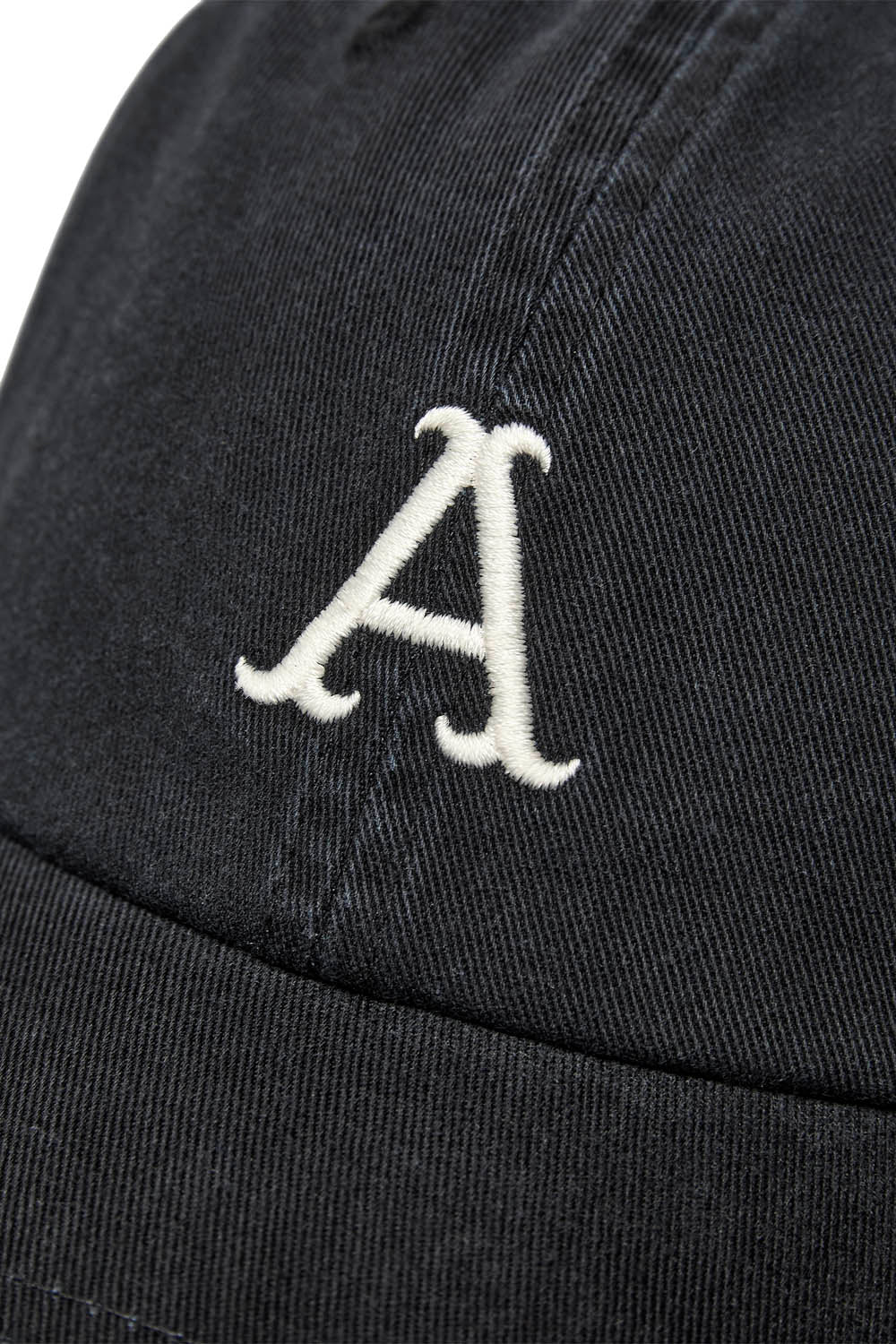 Close-up of a black baseball cap featuring a white embroidered letter 'A' on the front panel.