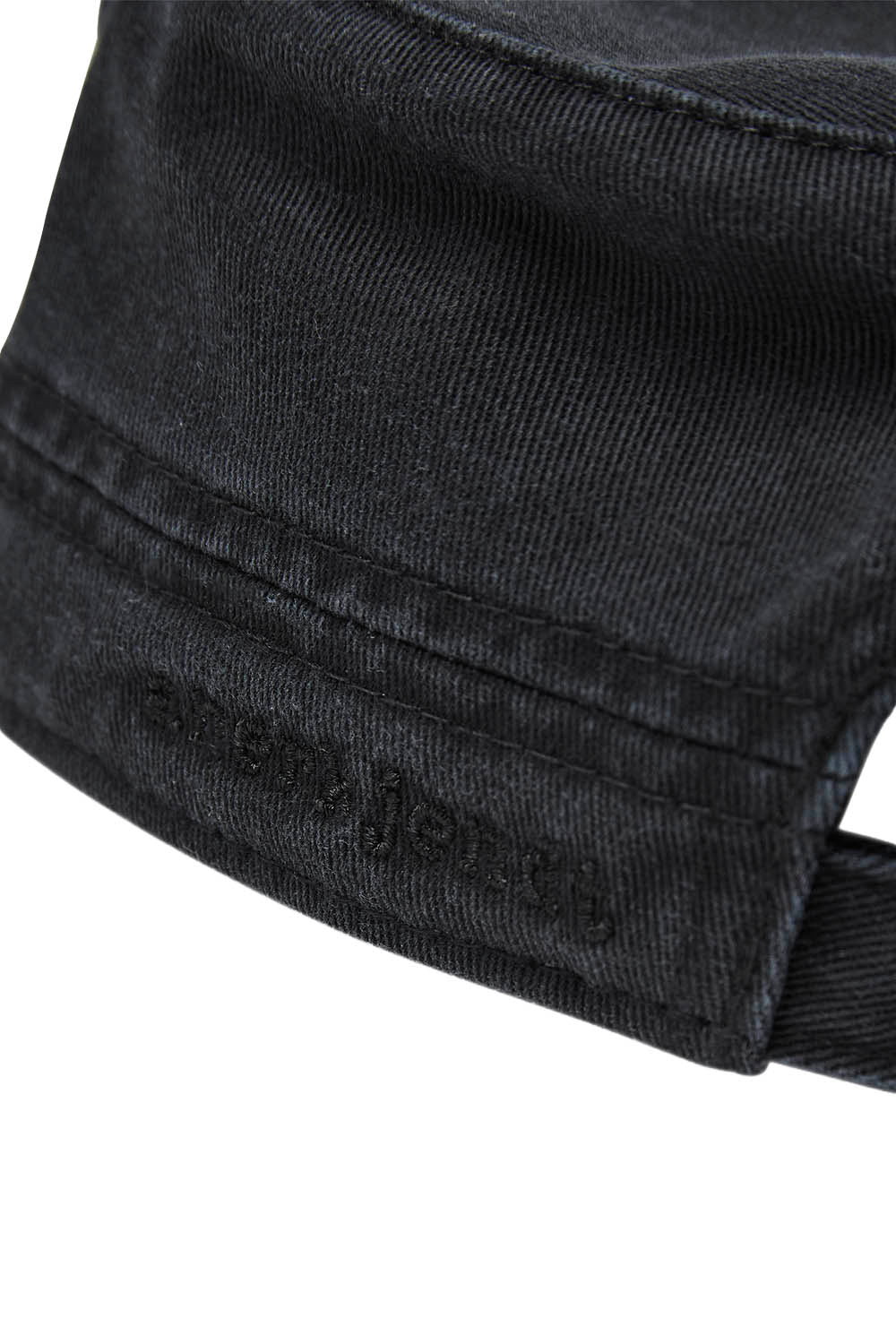 Close-up of a black denim cap showing the fabric texture and a debossed 'Fossil' logo on the side, set against a plain white background.