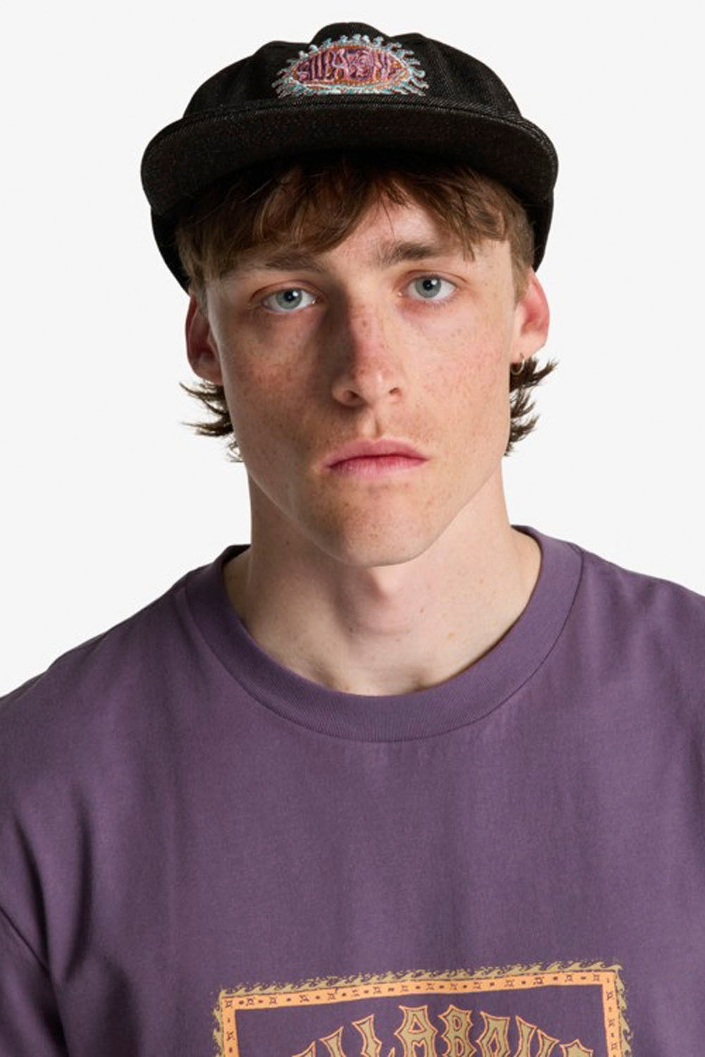 Person wearing a black cap and purple shirt with text on a white background