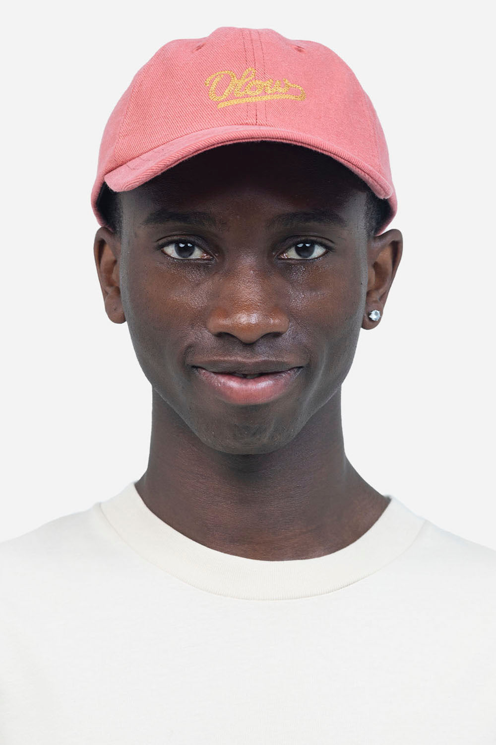 Person wearing a pink cap with 'Colours' logo on a white background