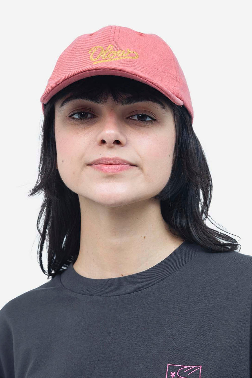 Person wearing a pink cap with 'Chase' logo and dark shirt against a white background