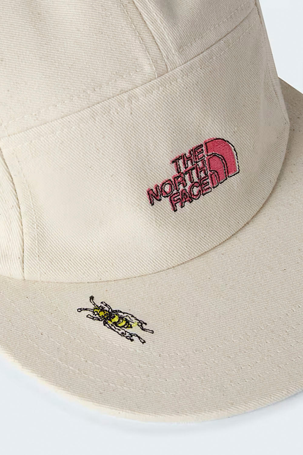 Beige bucket hat with embroidered logo and design on a white background