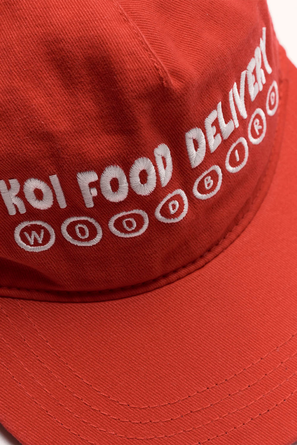 Red cap with 'Koi Food Delivery' text on a white background