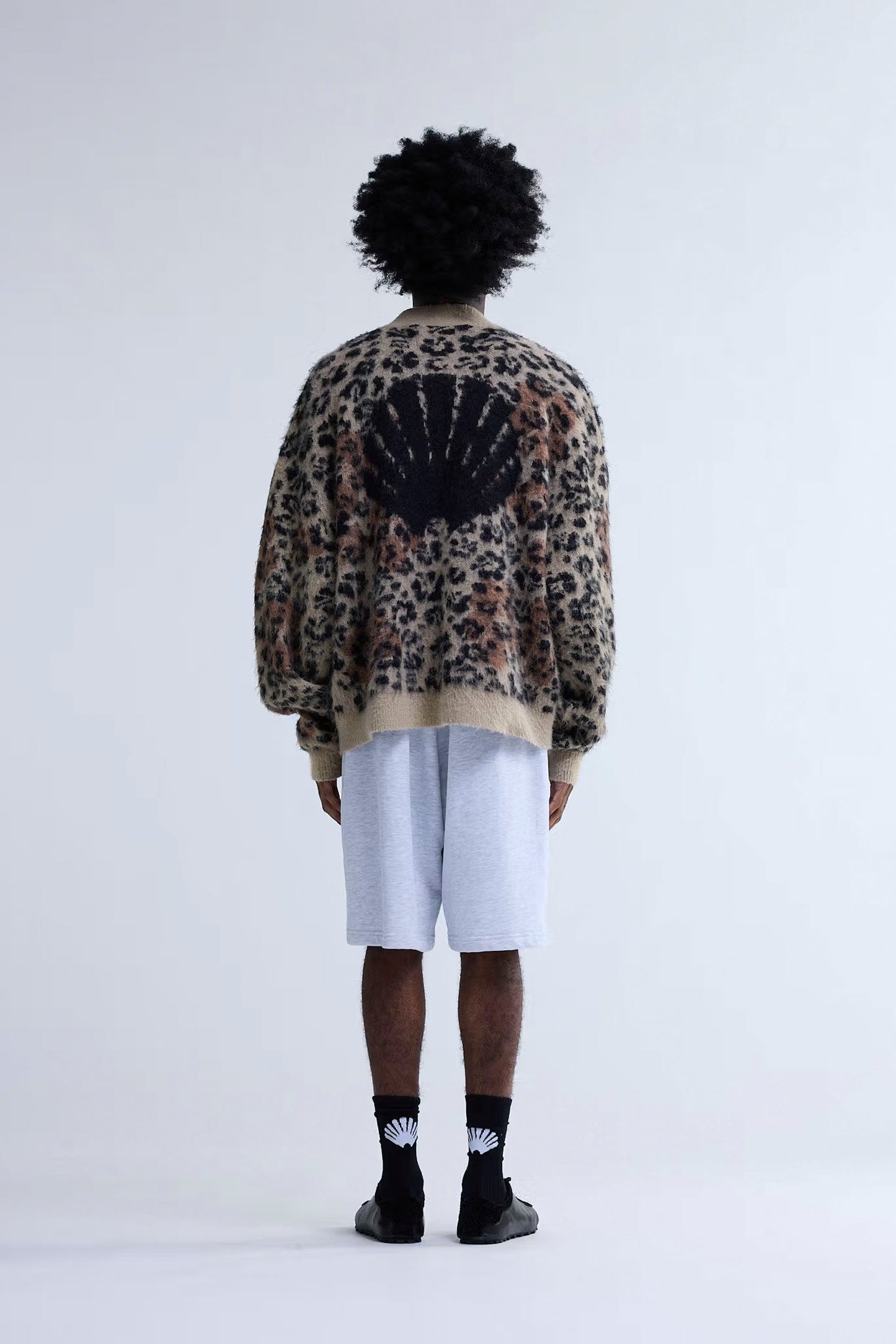 Person wearing New Amsterdam Surf Association Hibiscus Cardigan with a unique design on the back against a white background