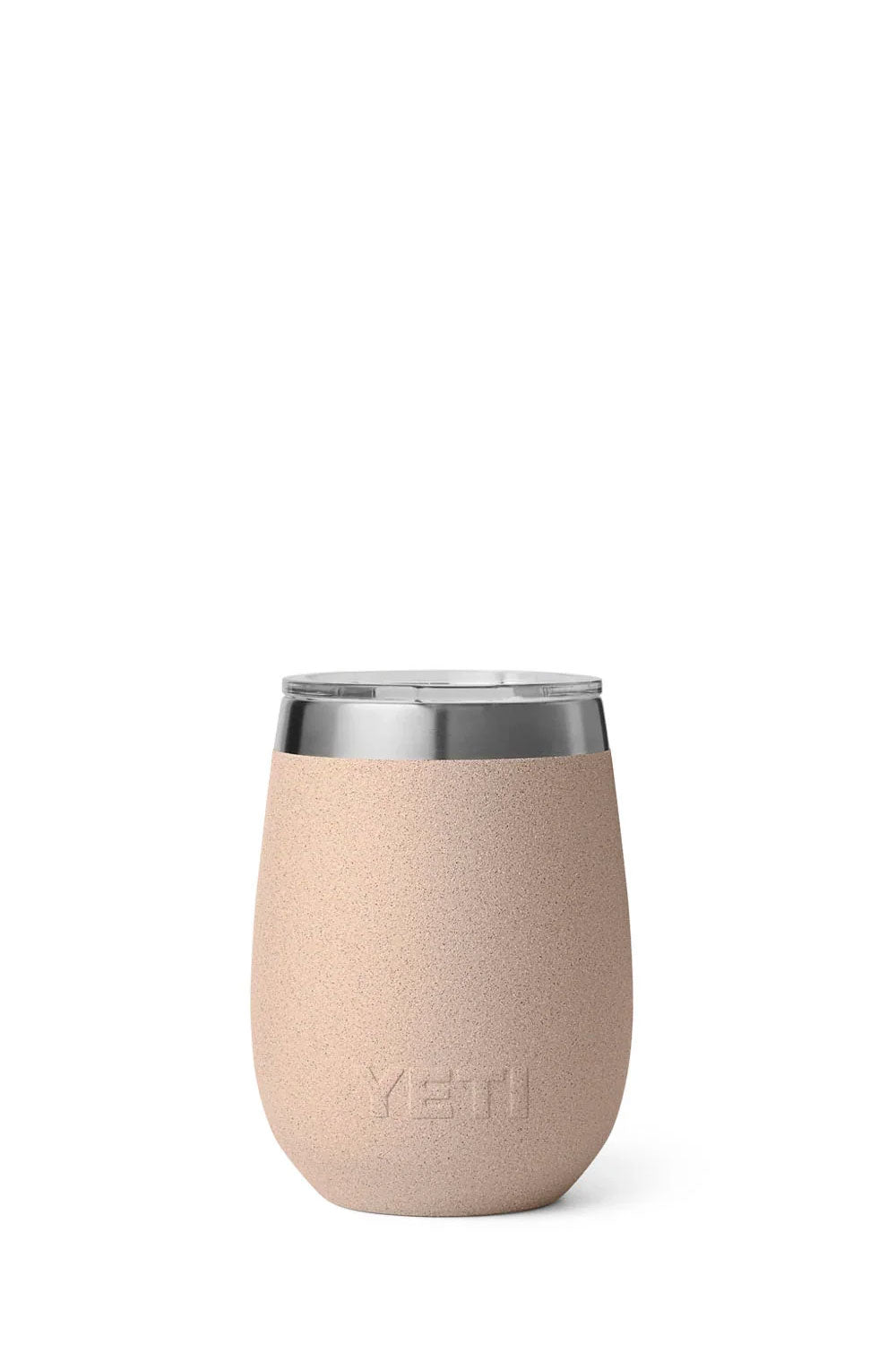 A YETI stemless wine tumbler in a light peach-beige color with a brushed silver metal rim, shown next to its clear lid containing two ice cubes, on a white background.