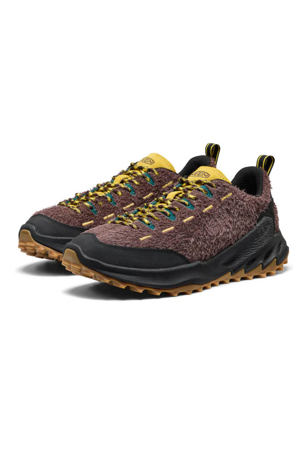 Pair of brown sneakers with yellow laces on a white background