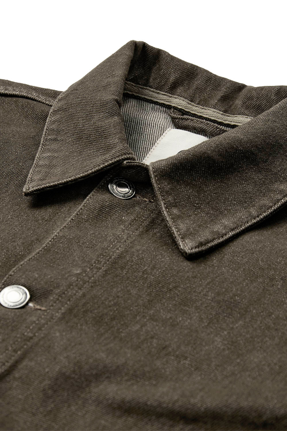 Close-up of a dark olive green jacket button-up shirt collar with silver metal snap buttons, set against a plain white background.
