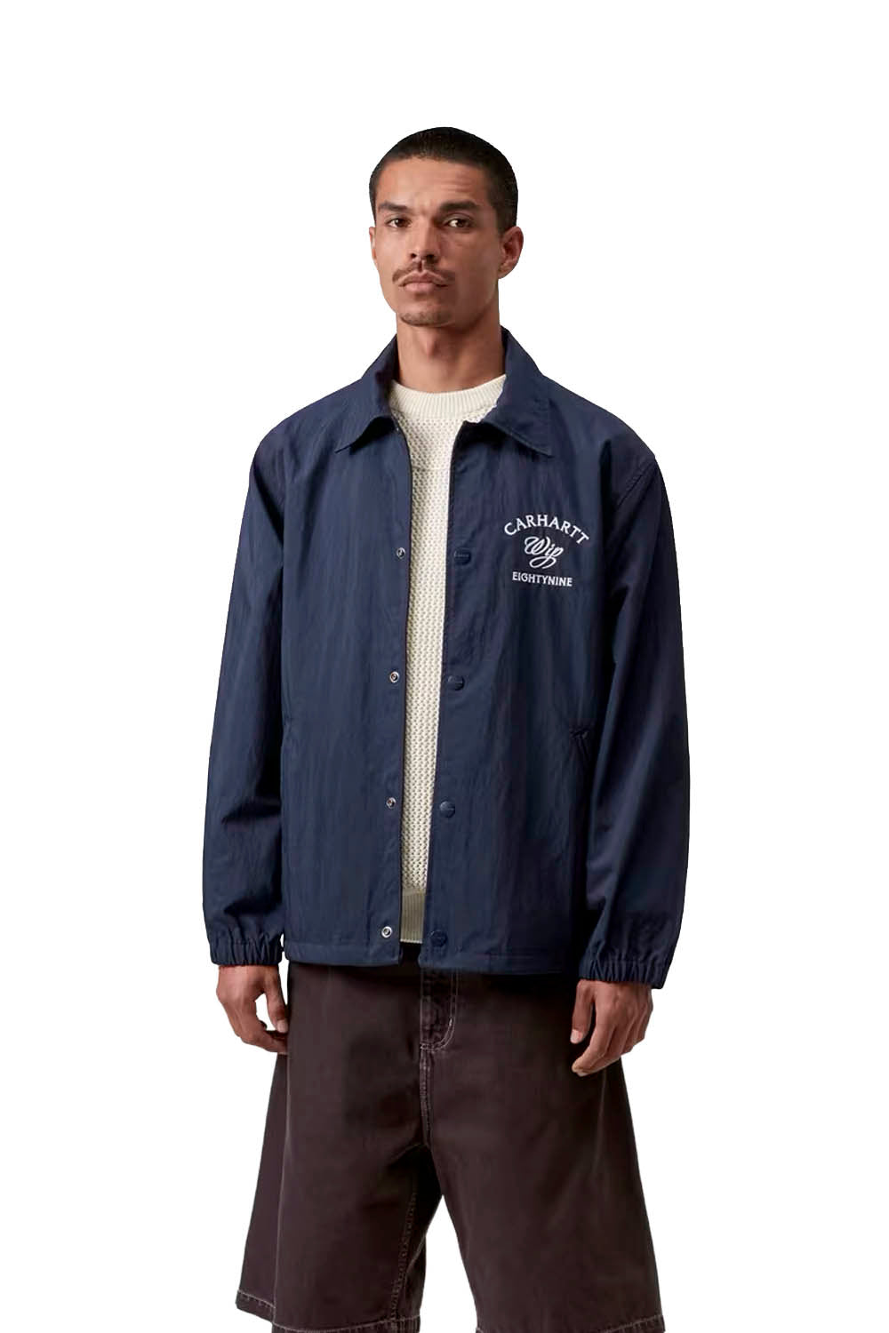 Man wearing a navy blue jacket with a brand logo on a white background