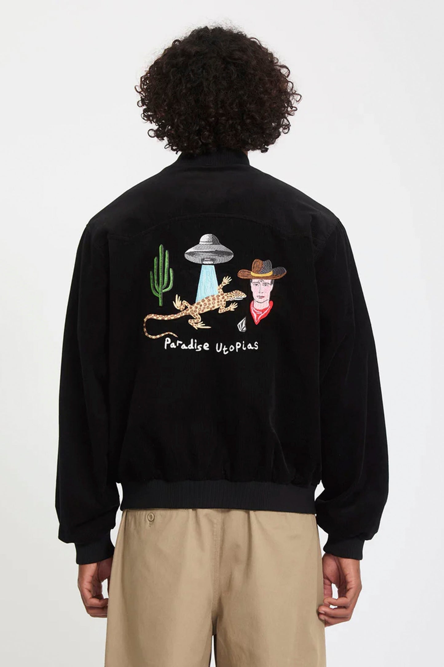 Person wearing a black VOLCOM Fa Mickey Mason jacket with a graphic design on the back against a white background