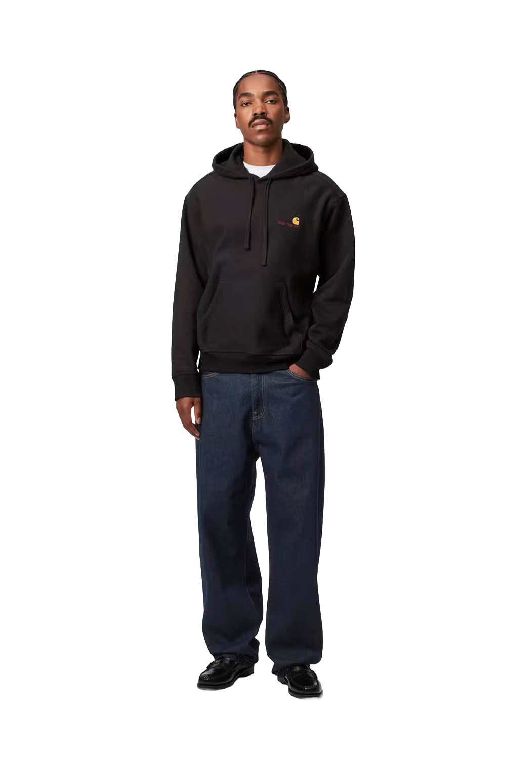 Man wearing a black Carhartt hoodie and blue jeans on a white background
