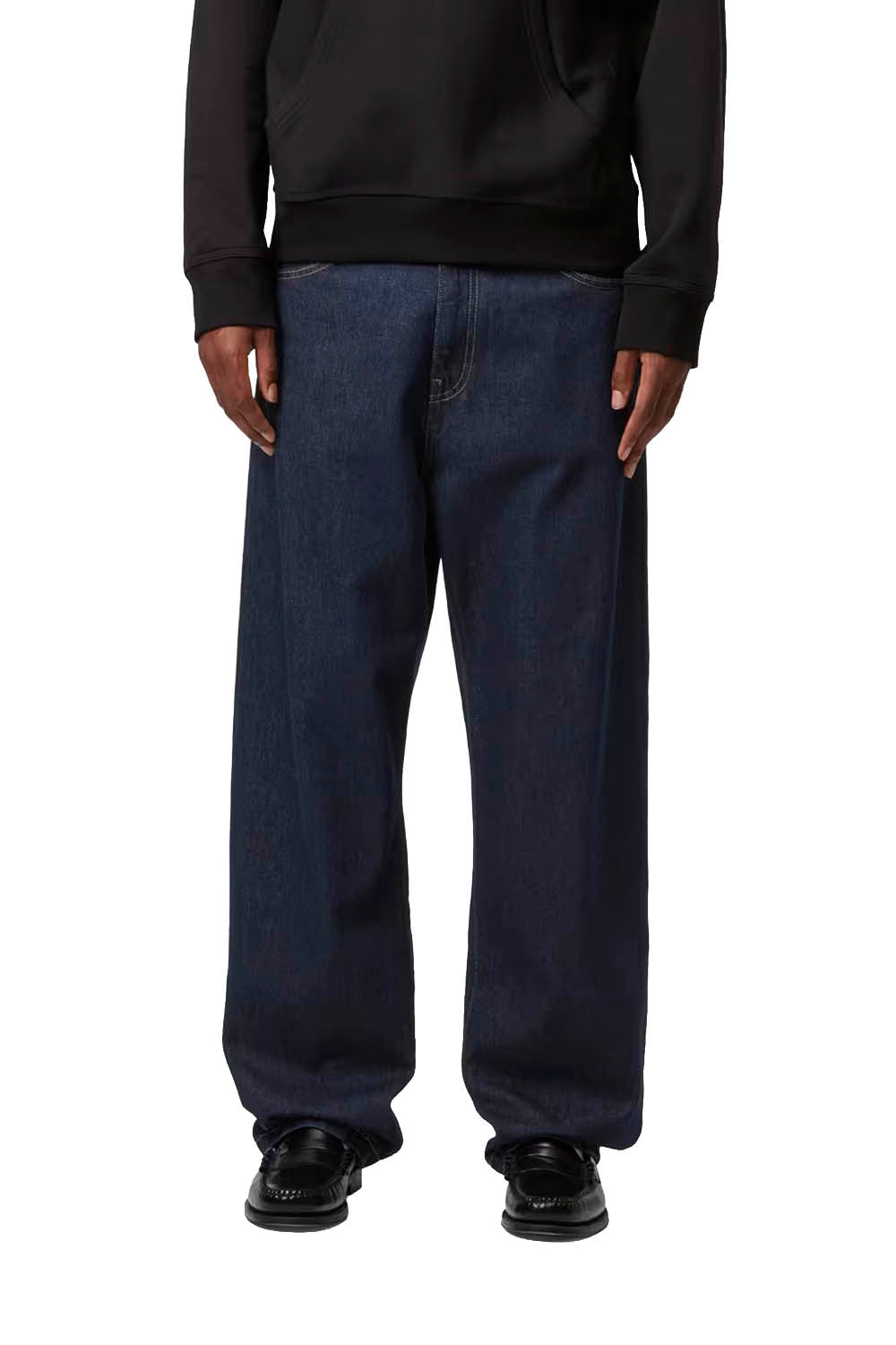 Man wearing a black Carhartt hoodie and blue jeans on a white background
