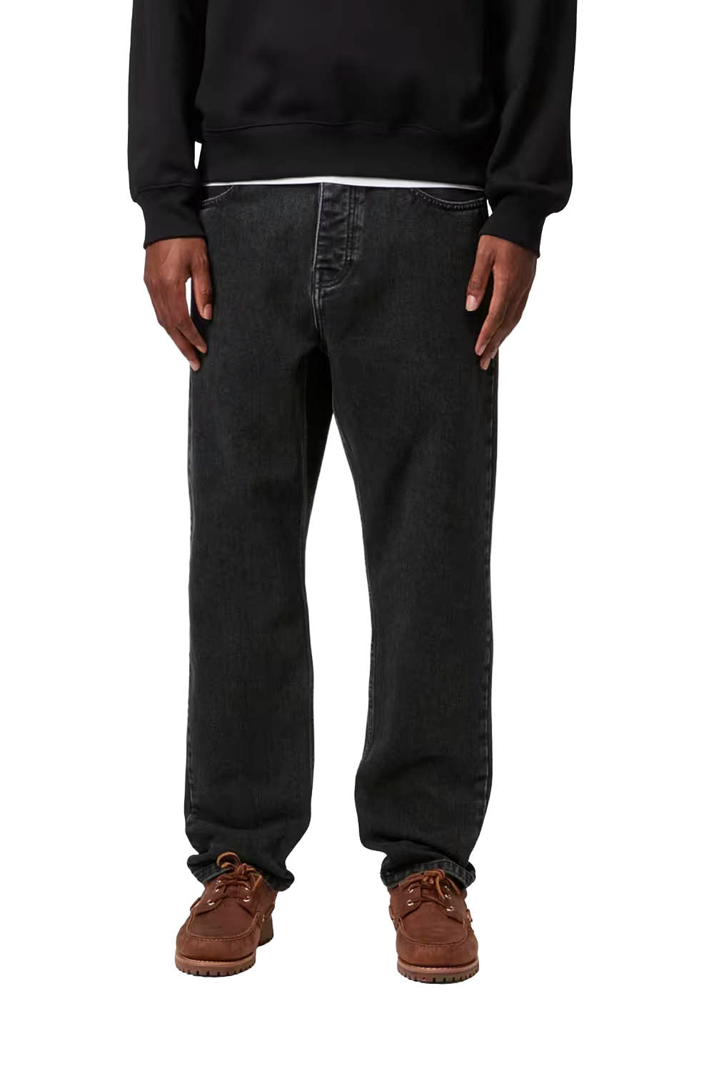 Person wearing black pants and brown boots on a white background