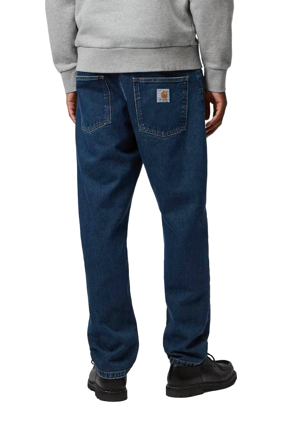 Man wearing a gray sweatshirt and blue jeans on a white background