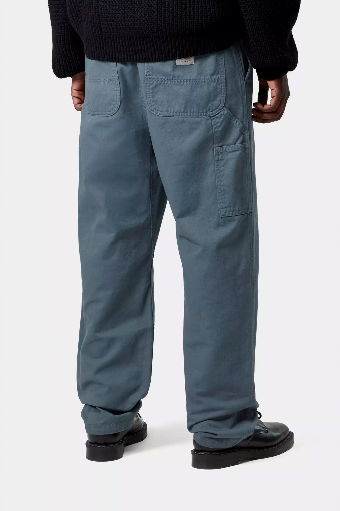 Person wearing Carhartt WIP Flint Pant in Cozy Blue on a white background