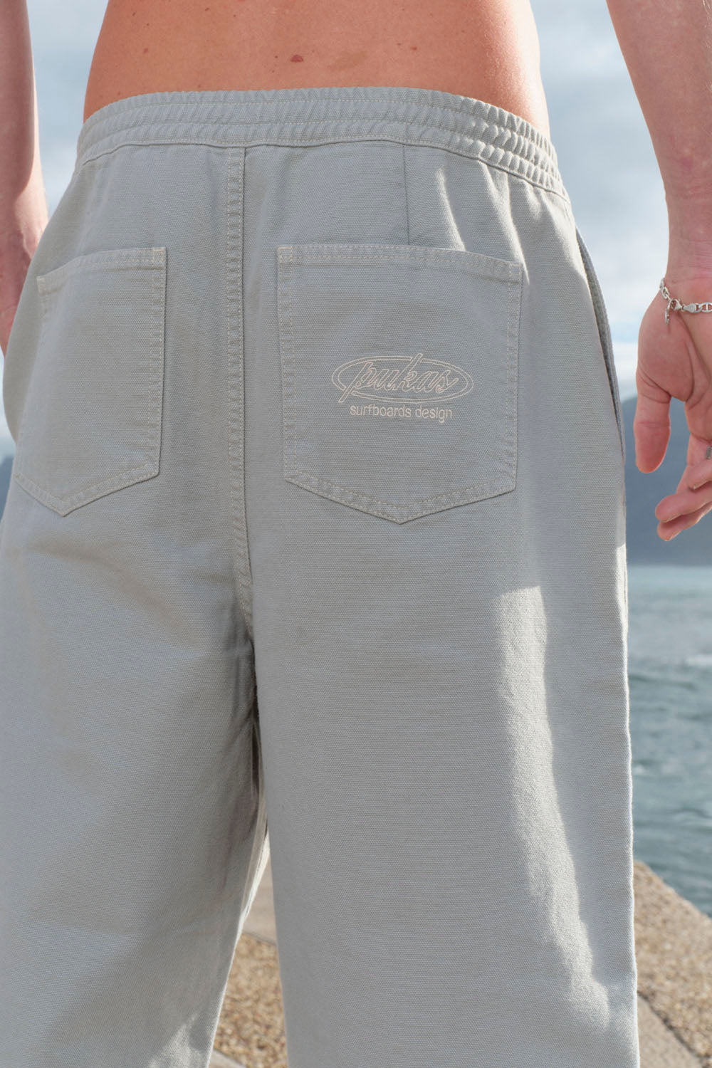 Light gray shorts with a brand logo on a beach