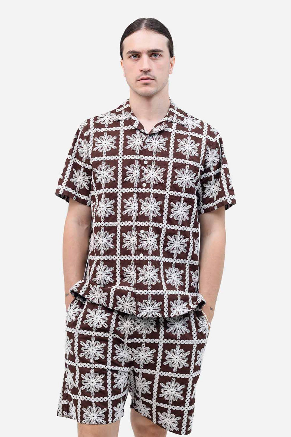 Man wearing a patterned outfit with a white background