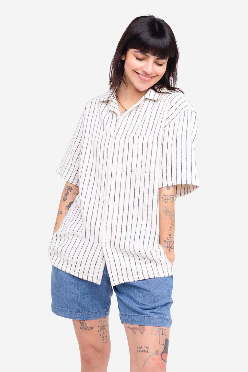 Person wearing a white striped shirt and blue shorts on a white background