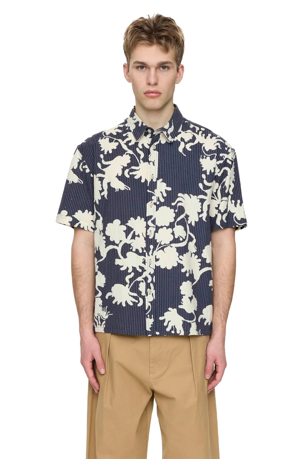 Man wearing a navy shirt with white floral pattern on a white background