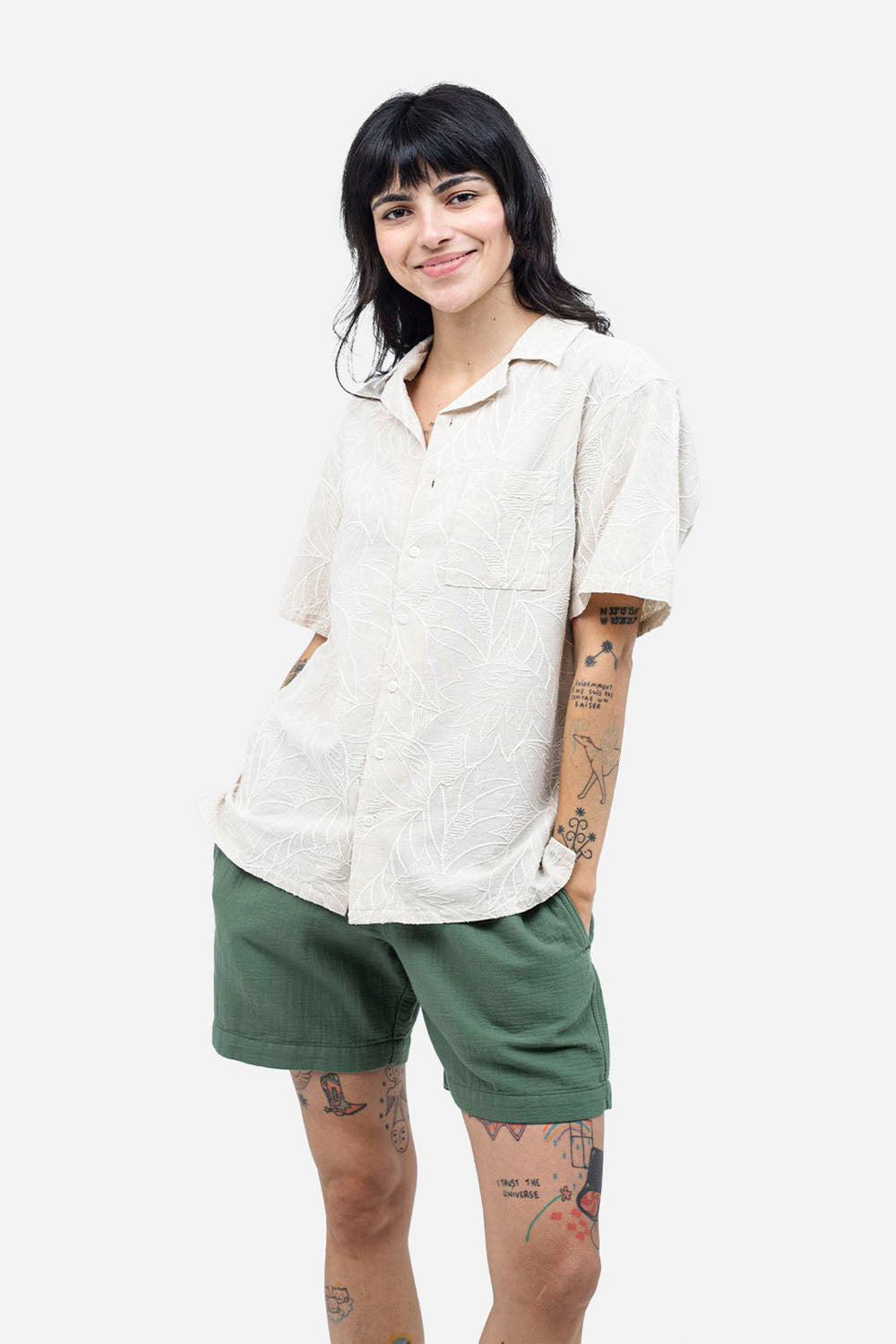 Person wearing a white shirt and green shorts on a white background