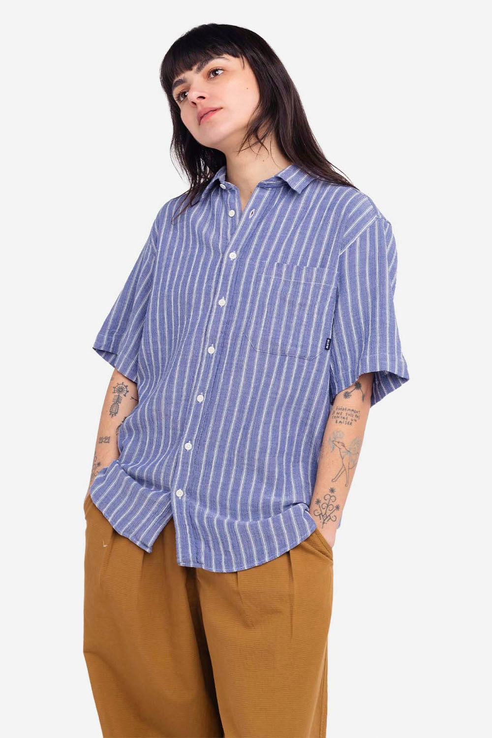 Person wearing a blue and white striped shirt with rolled-up sleeves on a white background
