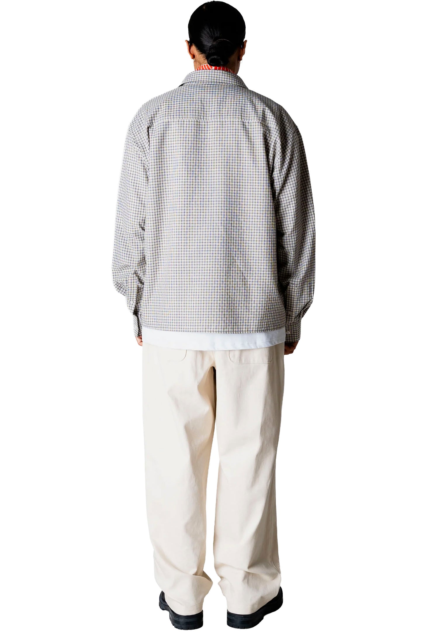 Person wearing a Woodbird Wbbuzo Check shirt and white pants on a white background