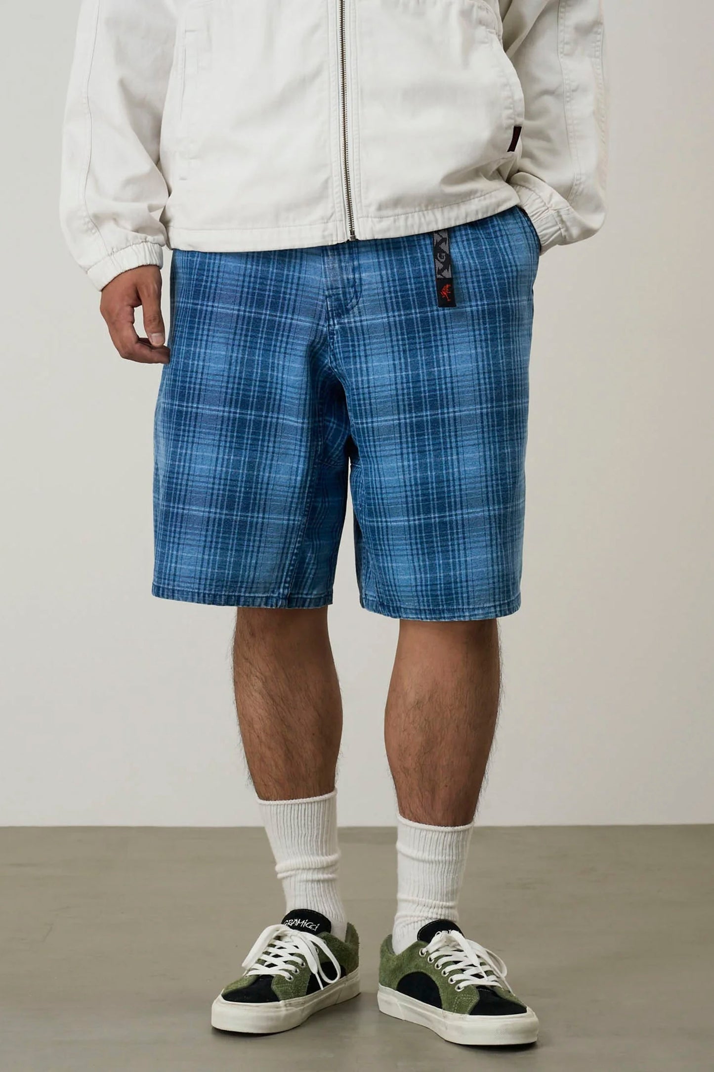 Person wearing blue Gramicci Lagoon shorts with a plain background