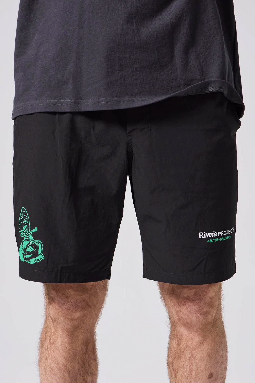Black shorts with green graphics and text on a plain background