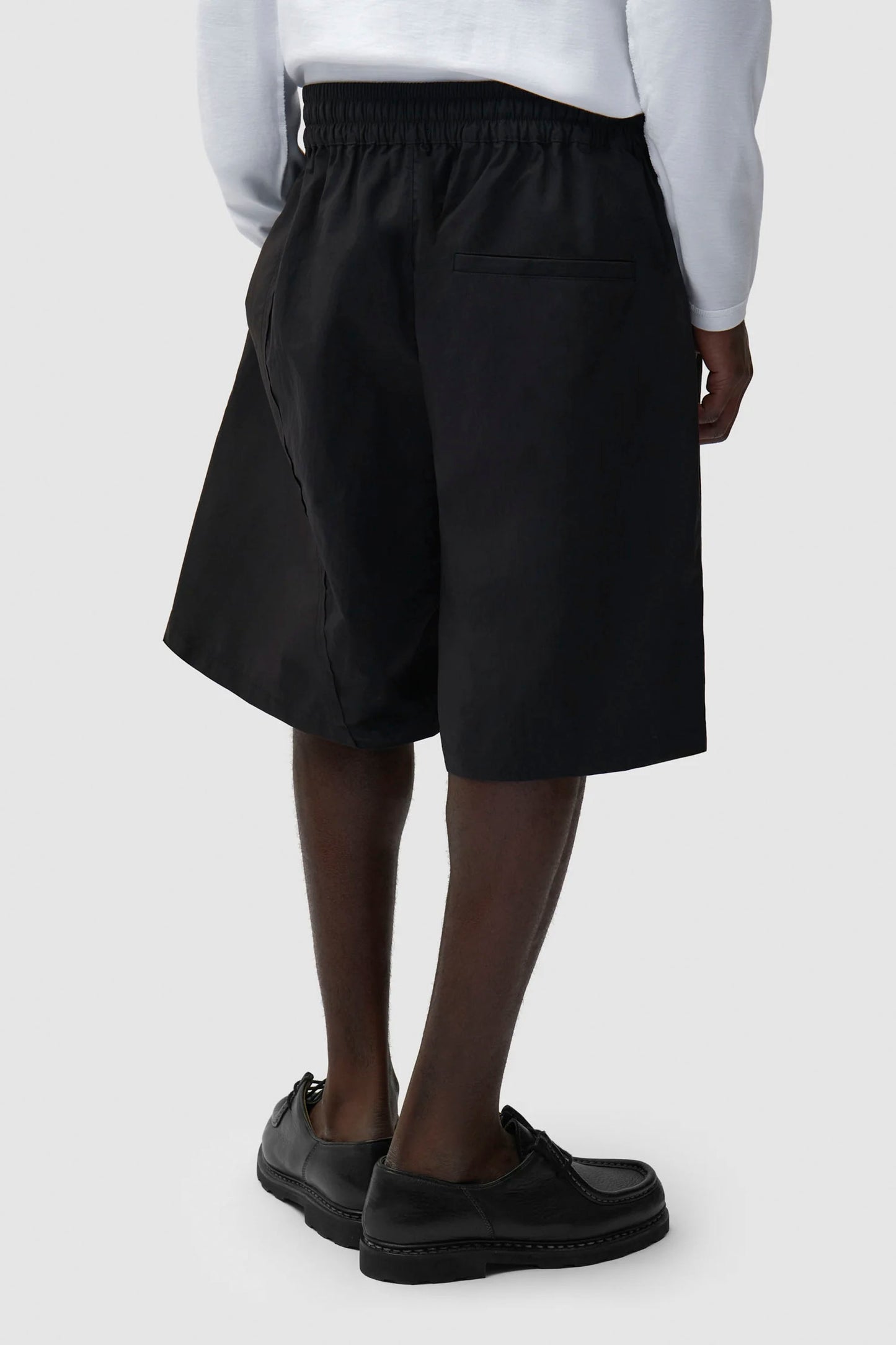 Person wearing ARTE Distorted Shorts Black on a white background