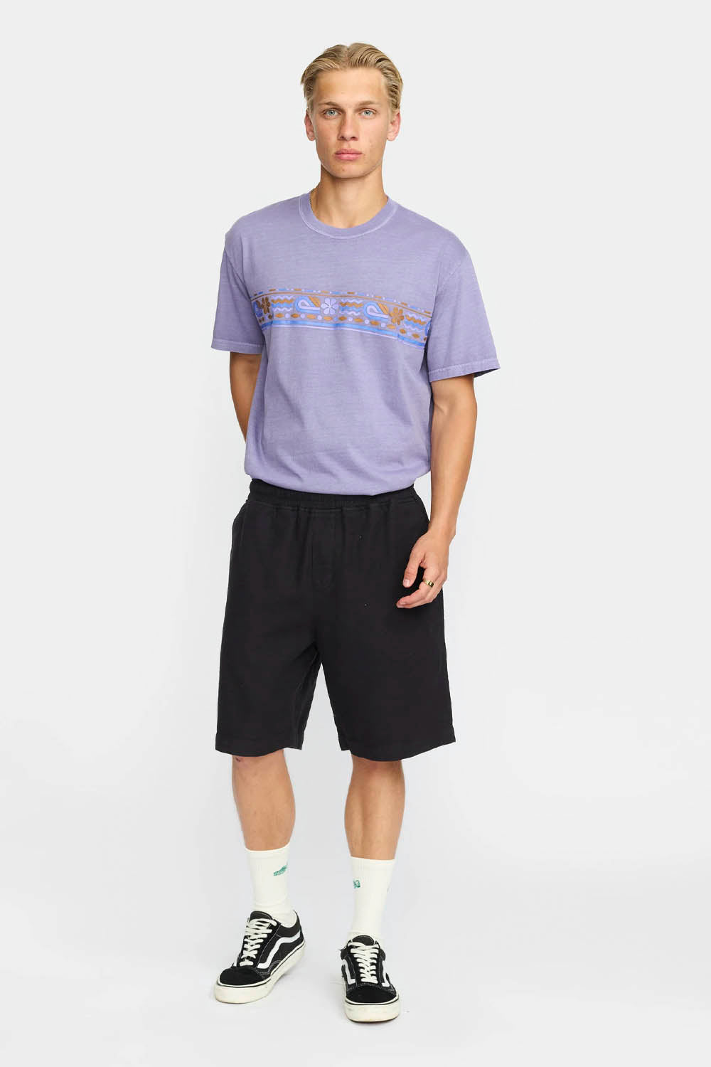 Man wearing a purple t-shirt and black shorts on a white background