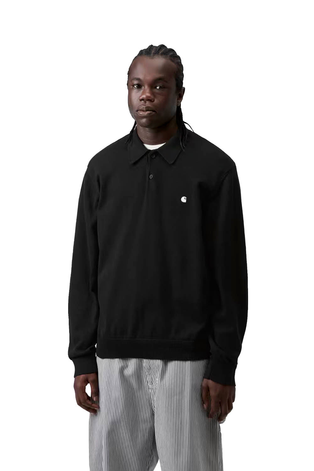 Person wearing a black long-sleeve shirt with a small logo on a white background