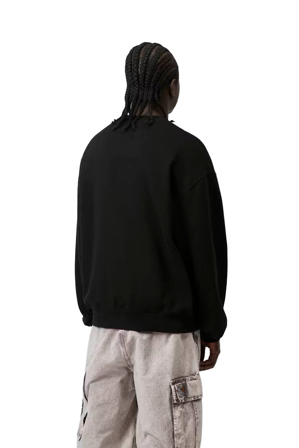 Person wearing a black sweatshirt and light gray pants on a white background