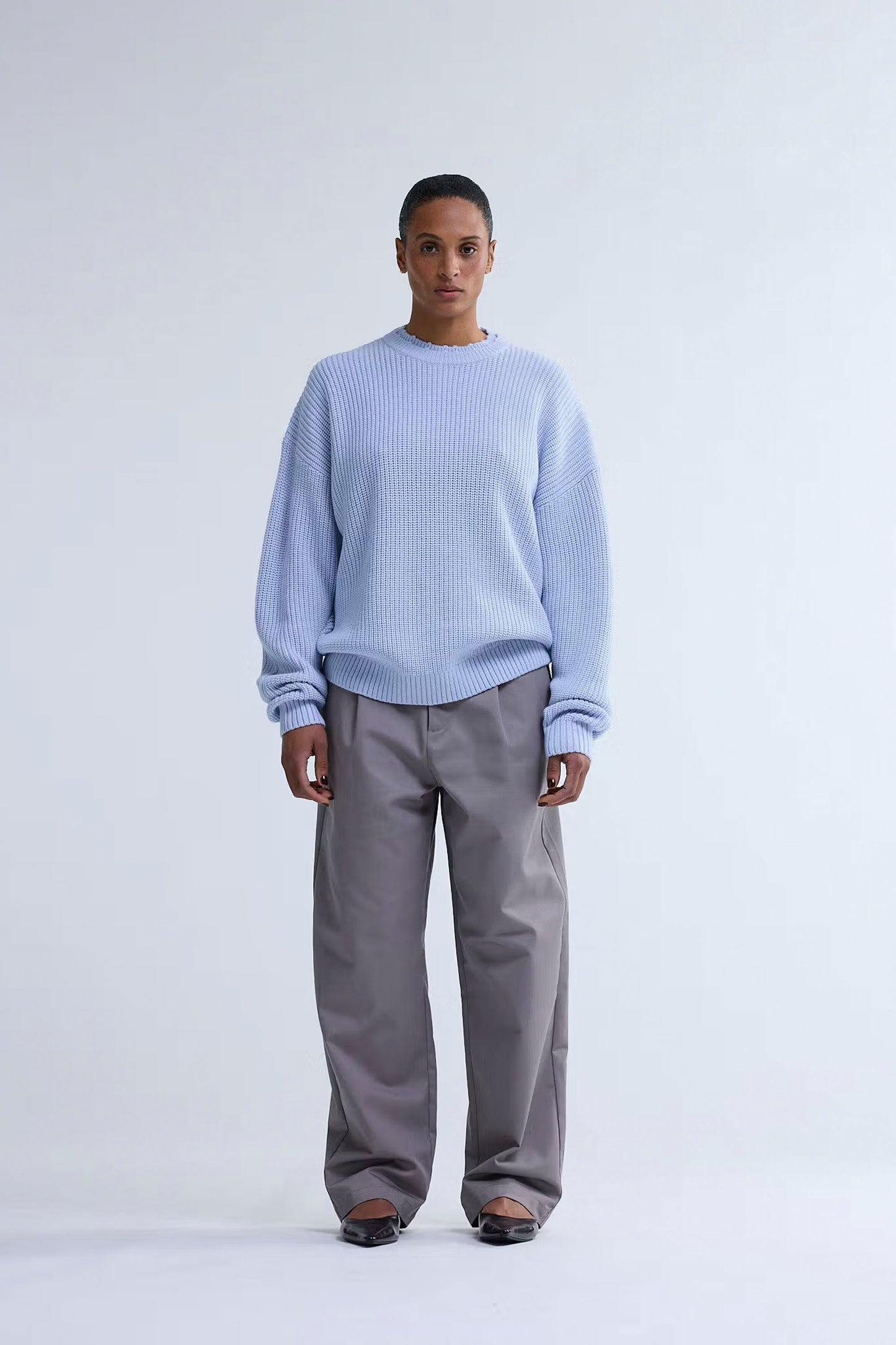 Person wearing New Amsterdam Surf Association Big Logo Crewneck in Baby Blue and gray pants on a white background