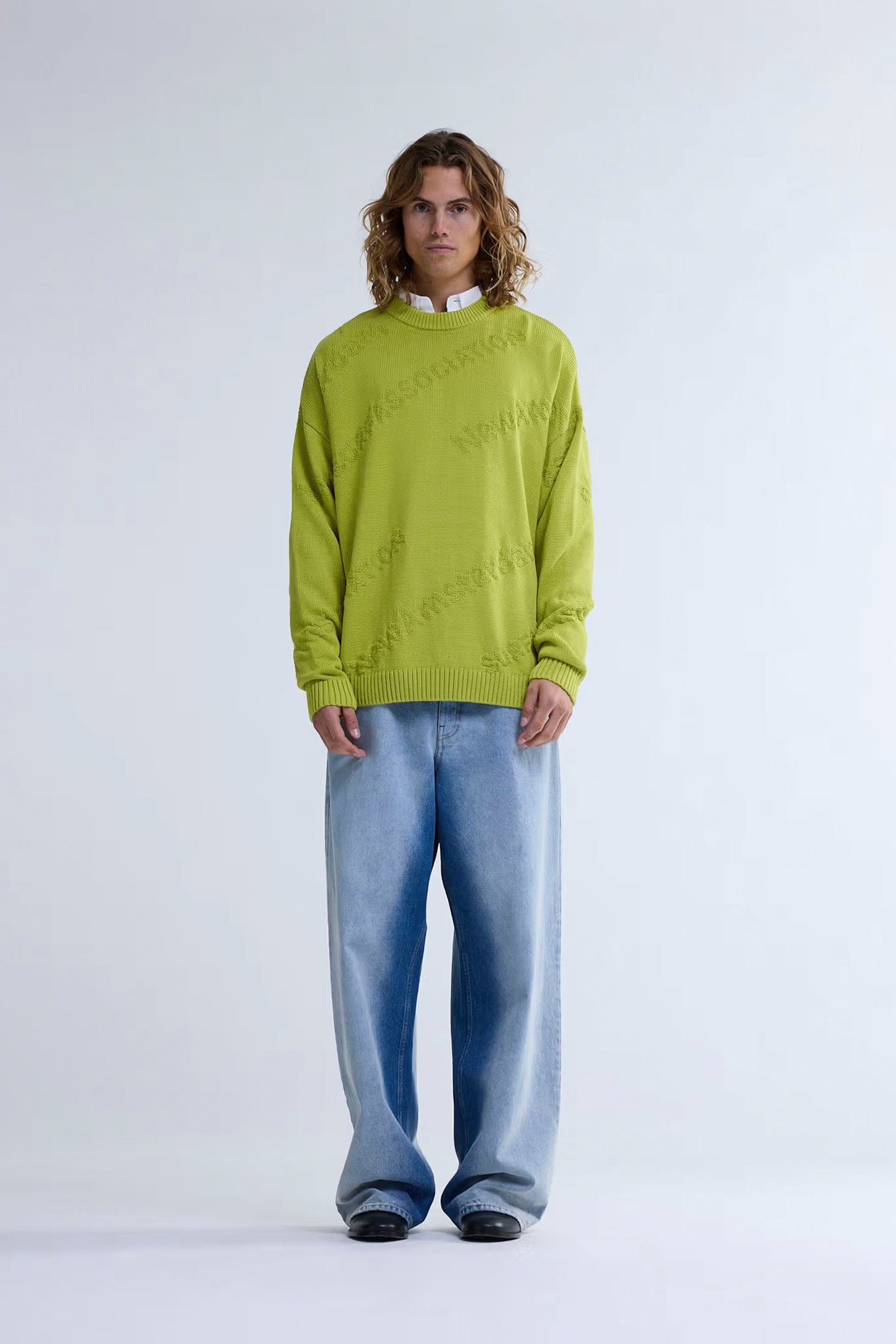 Person wearing New Amsterdam Surf Association Logo Jacquard Crewneck in Safety Yellow and light blue jeans on a white background