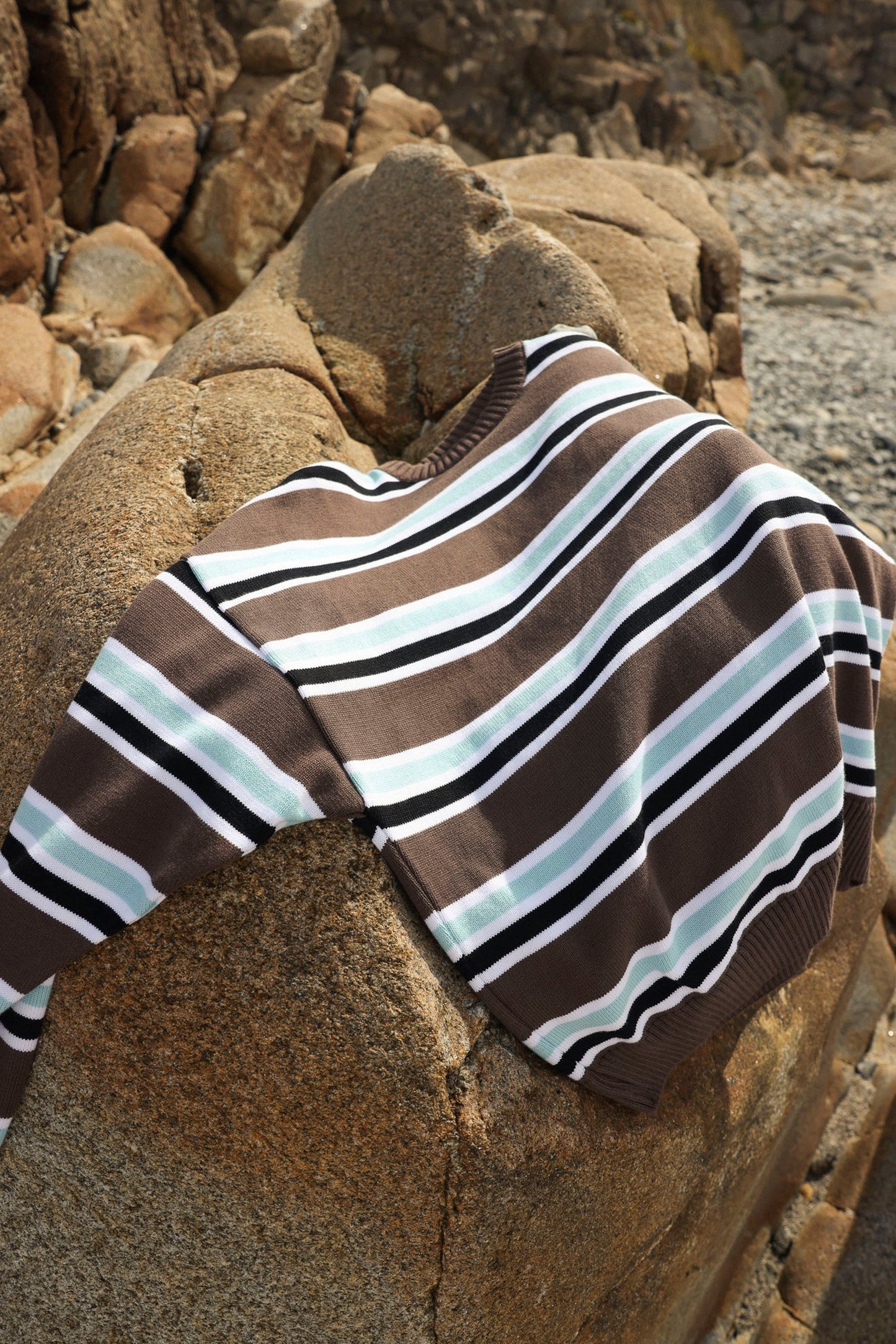 Nowhere Striped sweater on a rock Pukas Surf Shop