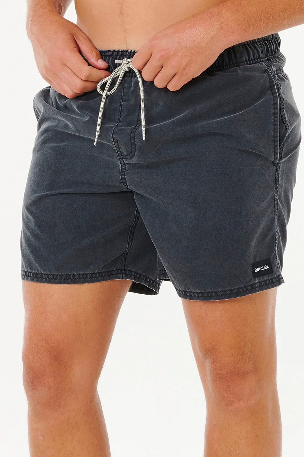 Person wearing dark denim shorts on a white background