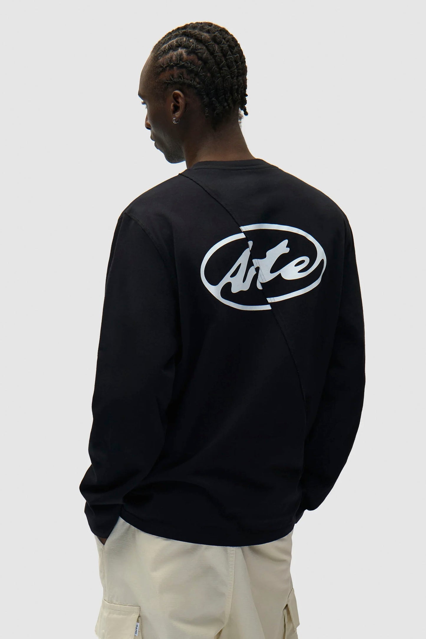 Person wearing a black ARTE circle logo longsleeve tee on the back against a white background