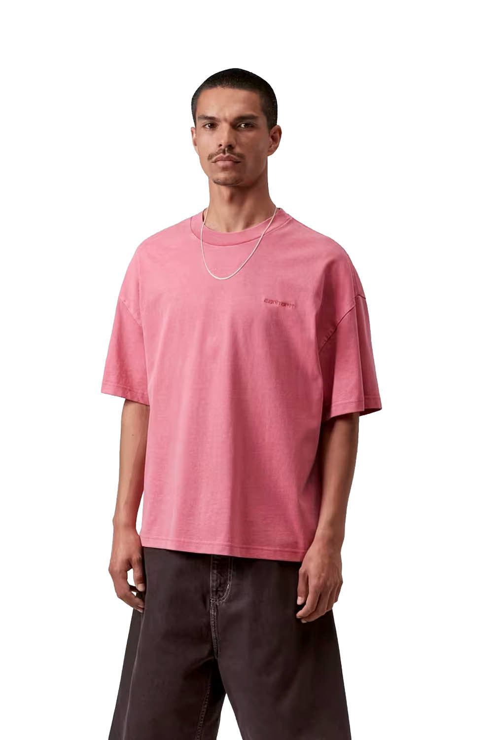 Man wearing a pink t-shirt with a small logo on a white background